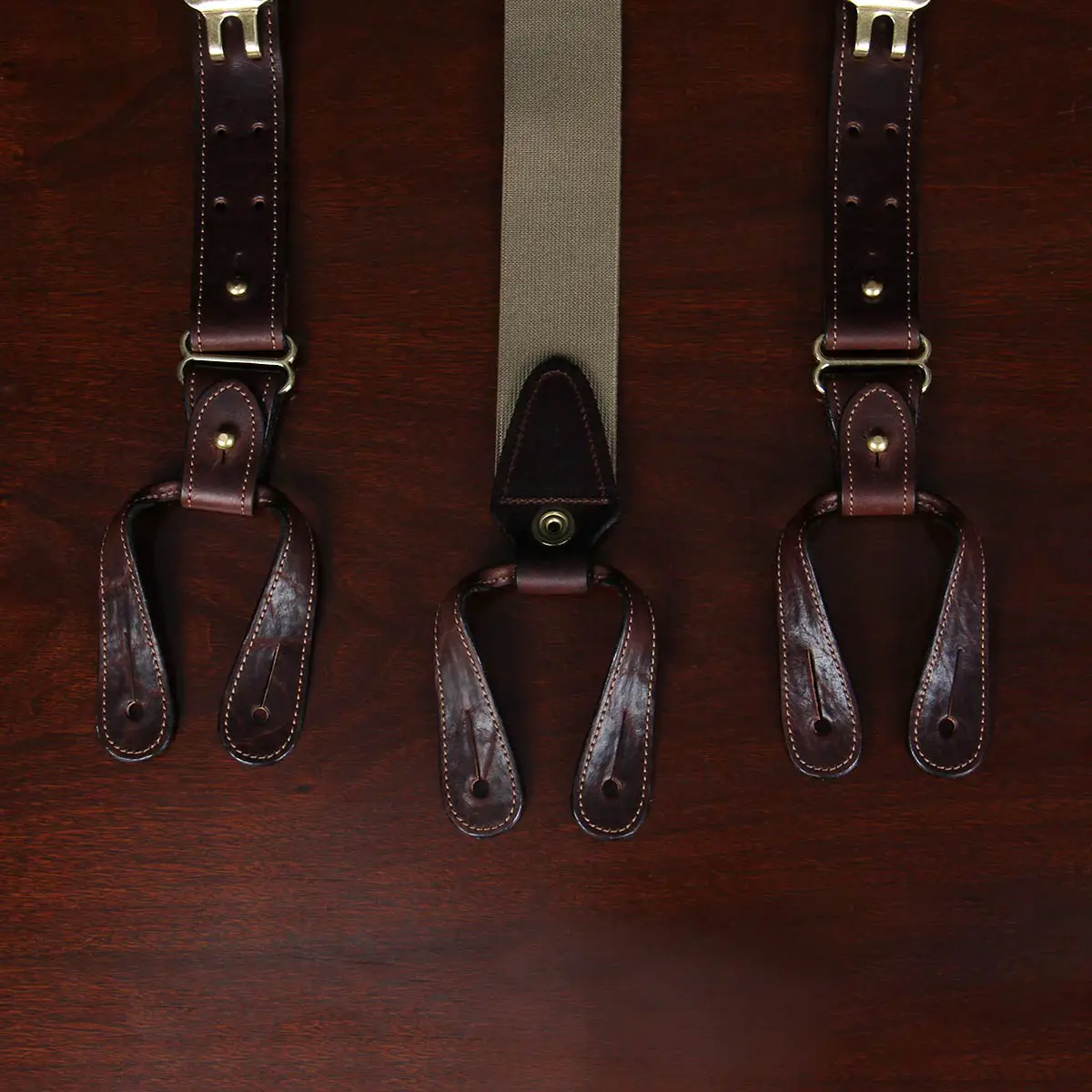 closeup view tobacco brown american buffalo leather suspenders and leather strips used to attach suspenders to pants