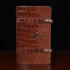 No.18 legal portfolio in alligator front view - id 001- on wooden table with black background
