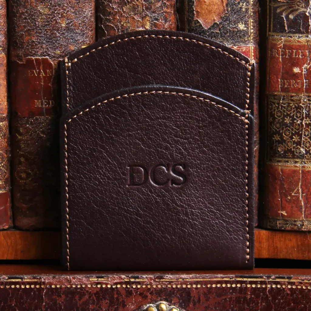 tobacco american buffalo leather front pocket wallet with initial personalization in front of vintage books