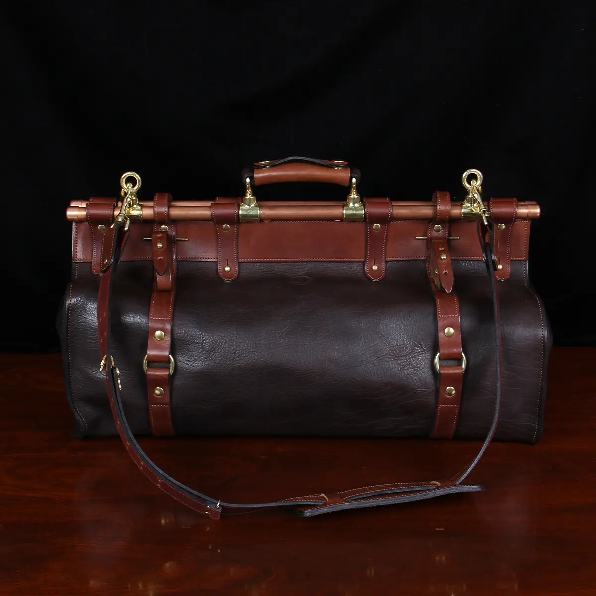 Back view of Dark brown buffalo leather No. 3 grip travel bag sitting on table