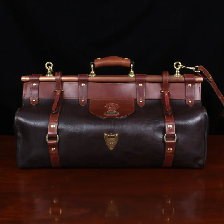 Front view of Dark brown buffalo leather No. 3 grip travel bag sitting on table
