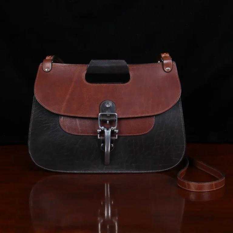 no 18 leather huntbag in tobacco buffalo - front view - on a wood table with dark background