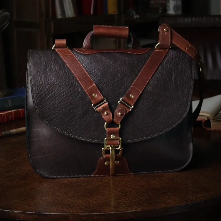 Dark brown American buffalo leather vintage-style No. 41 Commander Briefcase on antique table in darkly lit study