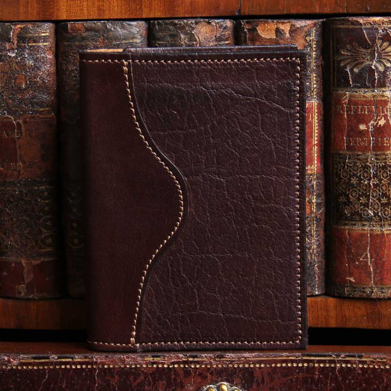 american buffalo tobacco brown no7 card wallet in front of vintage books