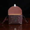 buffalo leather crossbody box bag on table - front open view