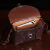 buffalo leather crossbody box bag on table - open view with iphone inside pocket