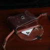 buffalo leather crossbody box bag on table - open view with phone, keys, and wallet