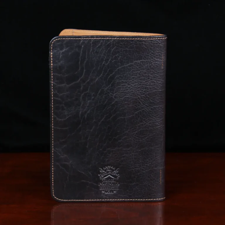 Leather travel portfolio in tabacco brown american buffalo on a wood table - back view