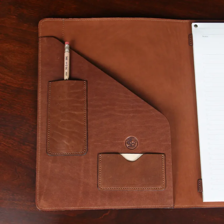 no 28 leather portfolio in tobacco buffalo - open view of pockets - on wood table with dark background