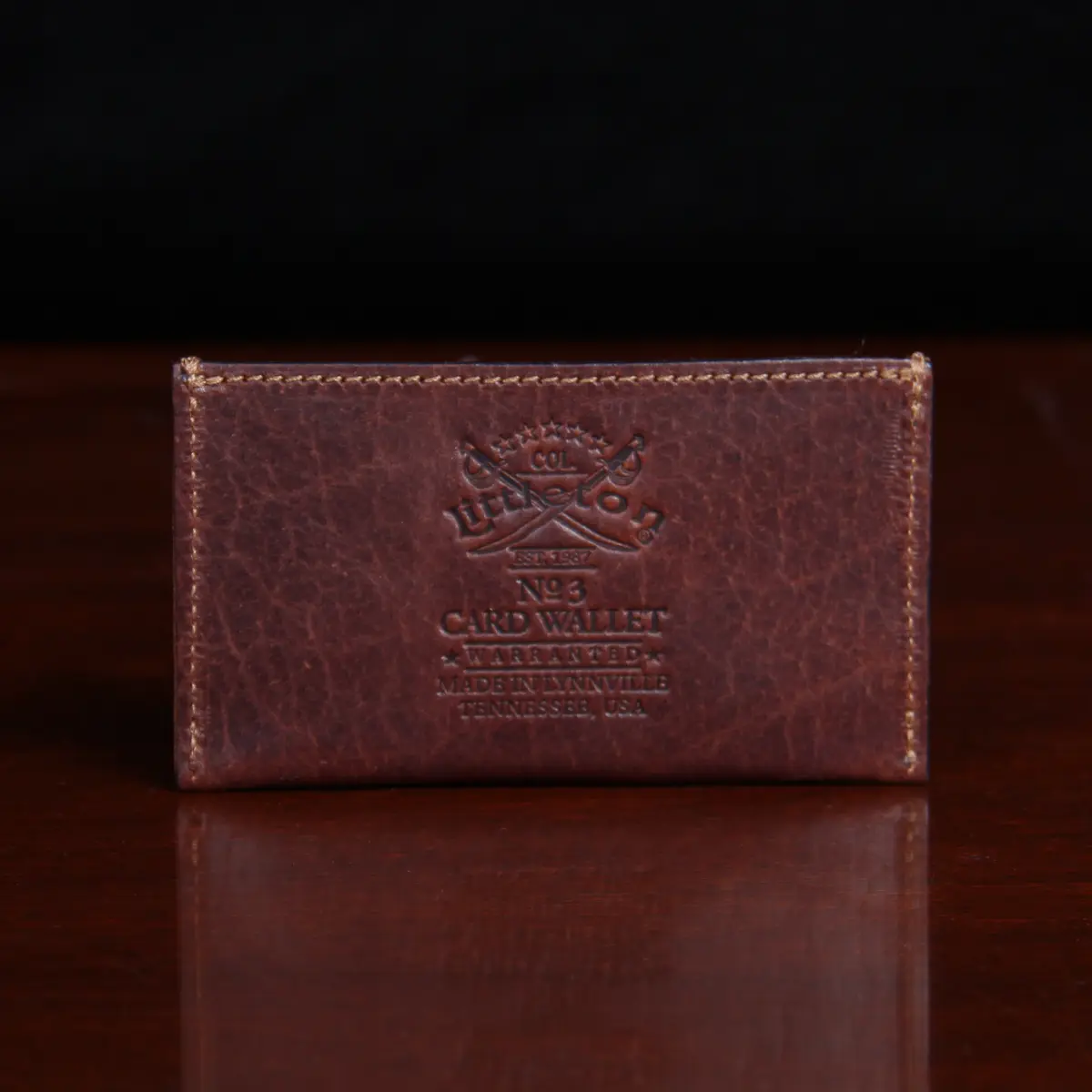 no3 card wallet in tobacco brown american buffalo - back view on wood table with dark background