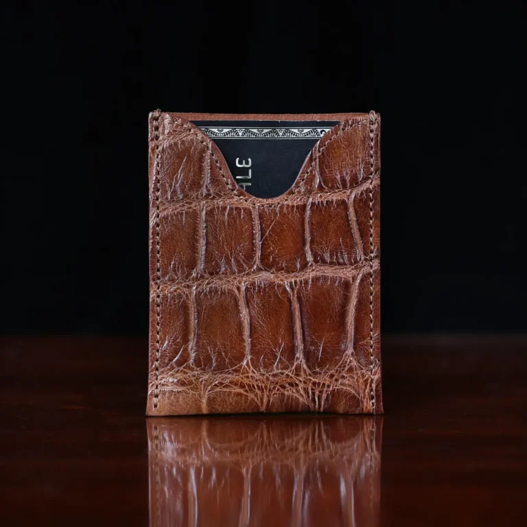 No. 4 Card Case in Vintage Brown American Alligator - ID 003 - front view with card on a wood table and dark background