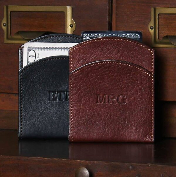black and brown leather front pocket wallet on wood shelf