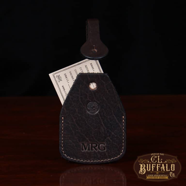 front view Tobacco Brown American Buffalo Luggage Tag on wood table and tag sticking out with CL Buffalo logo in bottom right hand corner