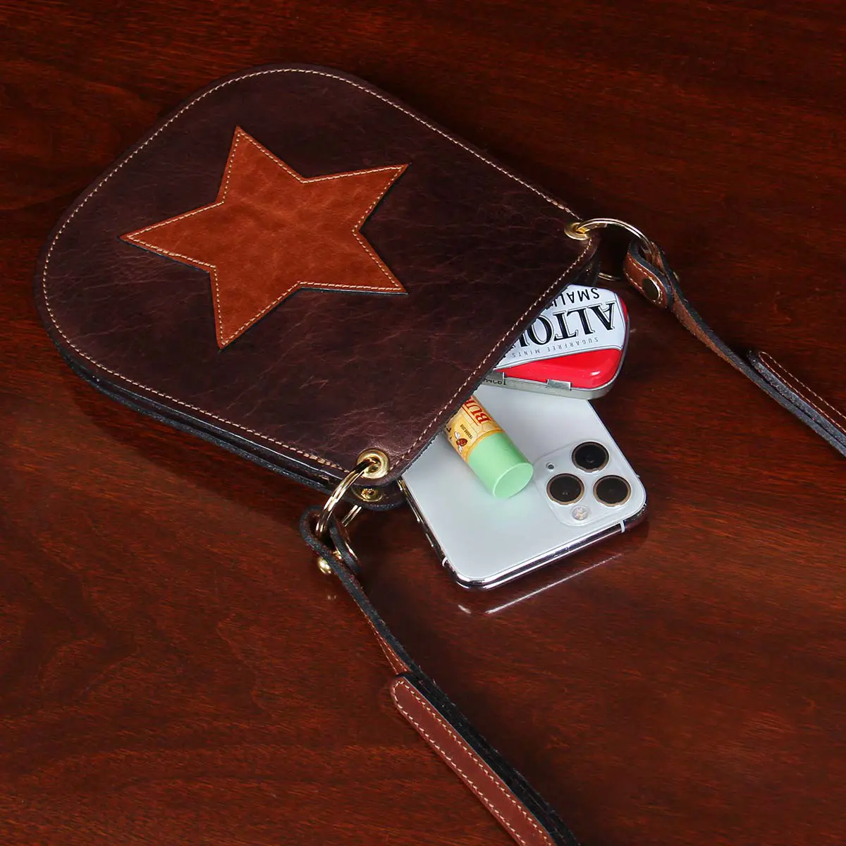 small leather purse laying on table with small items spilling out