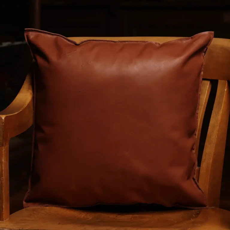 back of two tone leather pillow sitting in wood chair