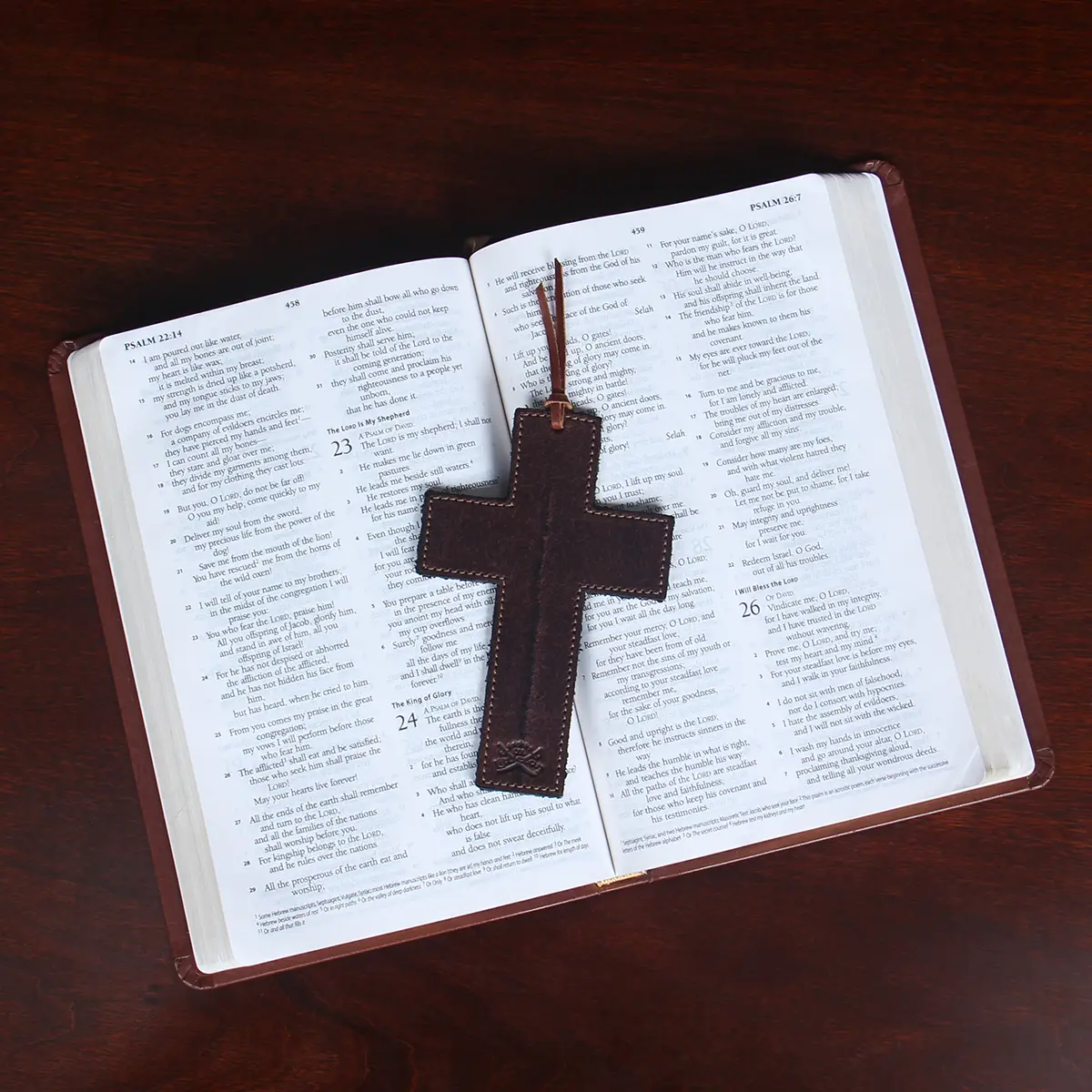 leather cross bookmark on open bible
