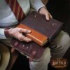 Colonel sitting holding the Tobacco Brown American Buffalo leather bible cover pulling a bible out