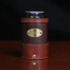 dark brown leather can coozie with soda can in it with plate