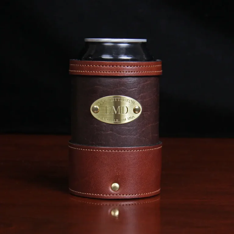 dark brown leather can coozie with soda can in it with plate