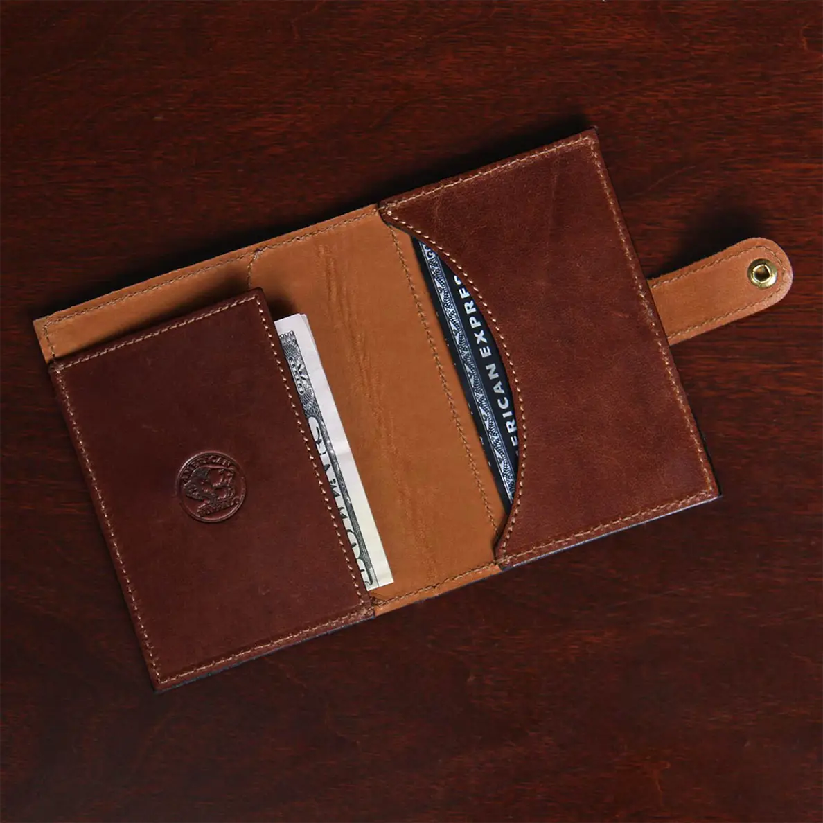 open view with money and credit cards of dark brown leather wallet with snap closure
