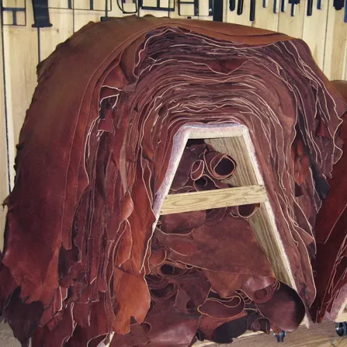 A large stack of leather hides draped over a wooden stand
