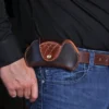 dark brown leather aviator sunglasses case with alligator trim shown on man's belt