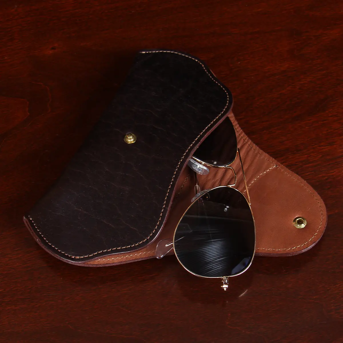 open view of dark leather aviator sunglasses case with light leather lining and sunglasses