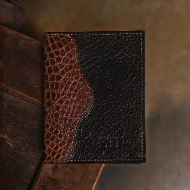 dark brown leather wallet with alligator trim showing forn on wood surface
