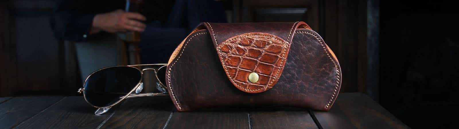 Category header image: dark tobacco brown american buffalo Aviator Eyecase trimmed with American Alligator with a pair of aviator sunglasses behind case
