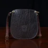 CL - dark brown leather Bella Bag small crossbody with boot on front made from alligator hide sitting on a wood table and black background - id 001 - back view