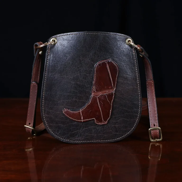 CL - dark brown leather Bella Bag small crossbody with boot on front made from alligator hide sitting on a wood table and black background - id 001