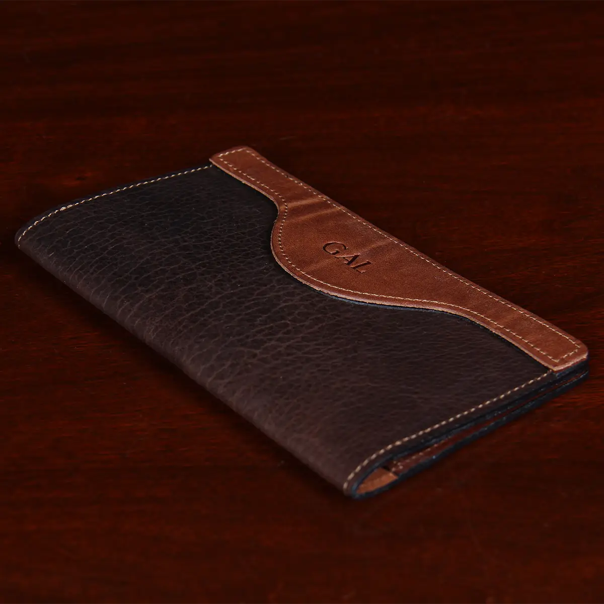two-toned leather checkbook cover laying on wood table