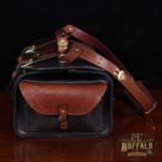 dark brown buffalo leather duffel bag on table - side view with pocket