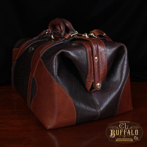 Vintage-style Gladstone dark brown american buffalo leather No. 5 Grip travel bag on wooden table - side view