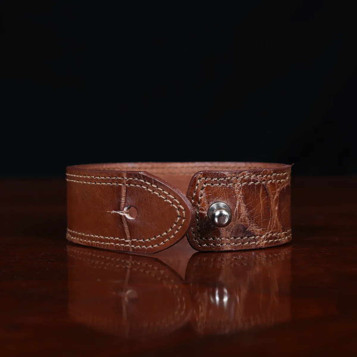 cuff-bracelet-alligator-no28-clasp view- on a wooden table with a dark background
