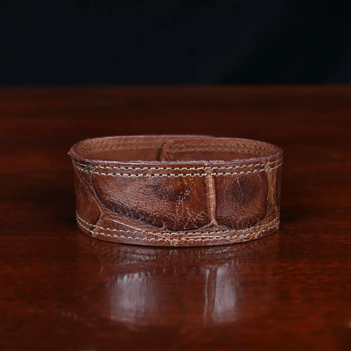 cuff-bracelet-alligator-no28-front view- on a wooden table with a dark background