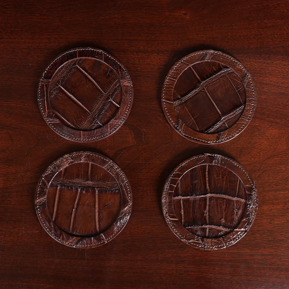 Round leather coasters in Brown American Alligator - set of 4 - ID 001 - back view of 4 coasters fanned out in a stack on black background