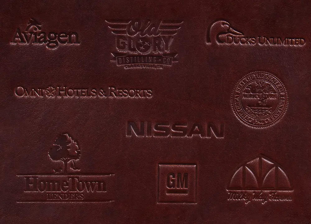 Stamped corporate logo examples: Aviagen, Old Glory Distilling Co., Ducs Unlimited, Omni Hotels & Resorts, Tennessee State Seal, Nissan, HomeTown Lenders, GM, Milkyway Farms