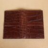 front and back view of small brown american alligator leather journal cover on cream background