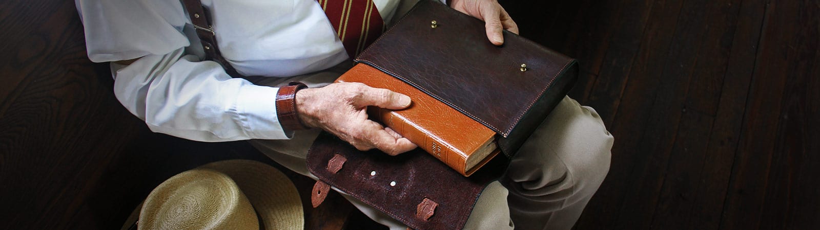 Bible Covers and Accessories Category Header - Man pulling a bible out of the dark Tobacco Brown American Buffalo leather No. 2 Bible Cover