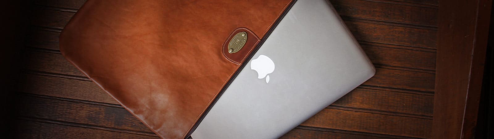 Laptop and iPad Category Header - MacBook laptop partially inside No. 3 Zip It leather pouch