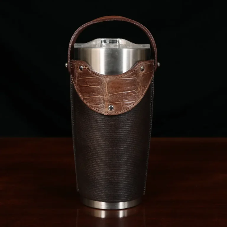 The front view of a leather tumbler sleeve show casing tobacco brown american buffalo and american alligator trim.