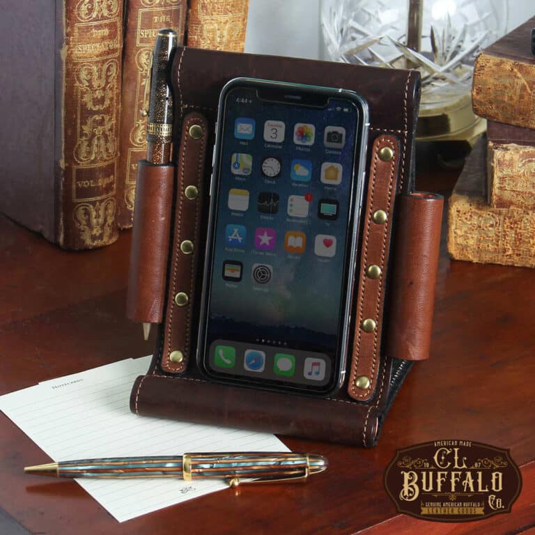 Tobacco Brown American Buffalo Phone Stand Holder with phone on table next to fancy pen and antique books
