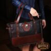 Bentley Tote in dark Tobacco Brown American Buffalo with contrasting vintage brown American Steerhide Trim draped over a woman's arm dressed in a navy leather jacket