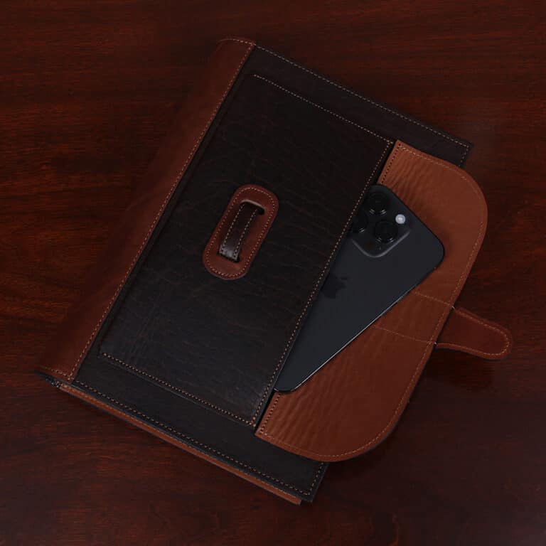 No. 1 Steno Padfolio in Tobacco Brown American Buffalo with Vintage Brown Steerhide Trim - view of front pocket with the flap open and a cell phone coming out