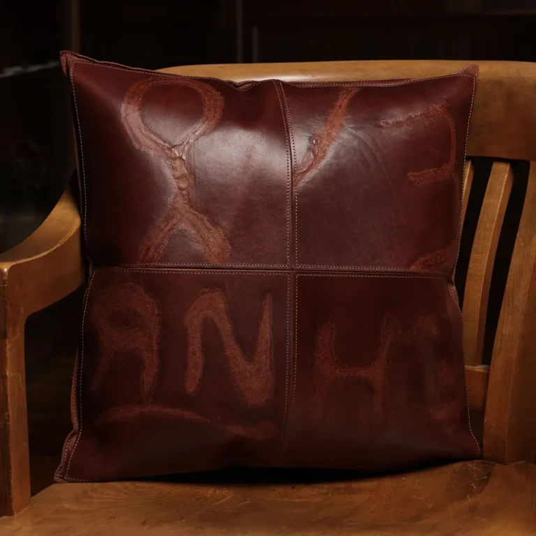 front of two tone leather branded pillow sitting in wood chair