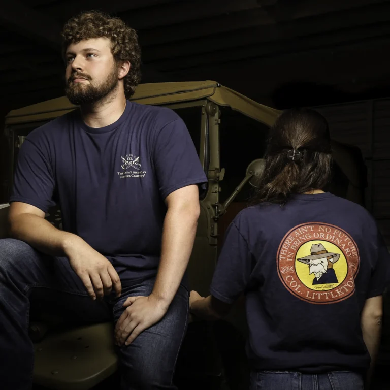 men and woman wearing the navy blue col. littleton shirt