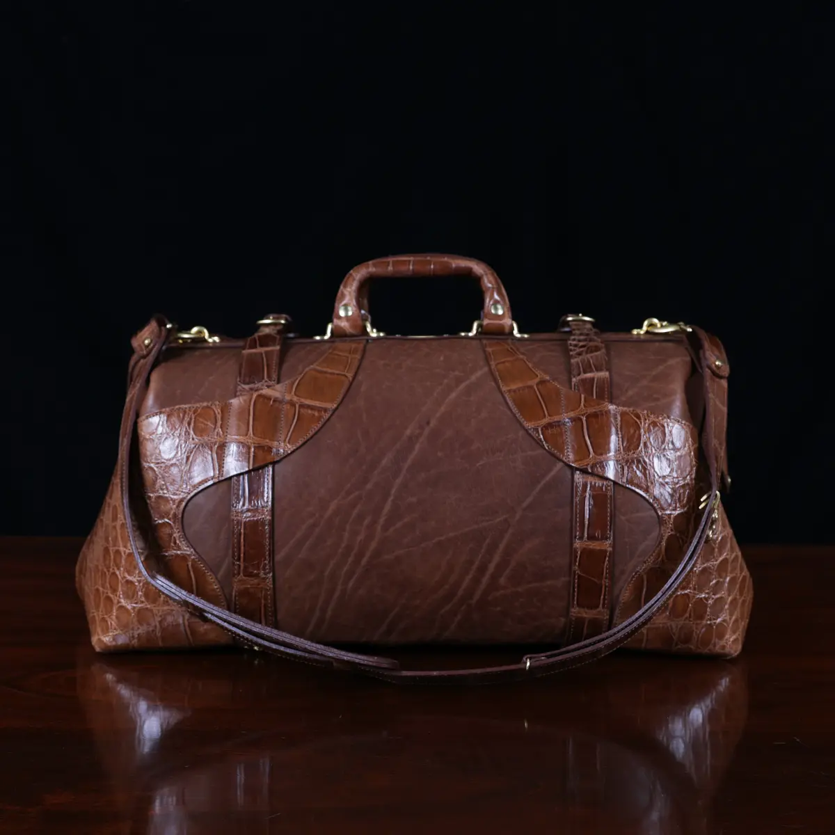 no 5 grip in steerhide with brown american alligator trim - back view - on a wood table with black background - ID 001