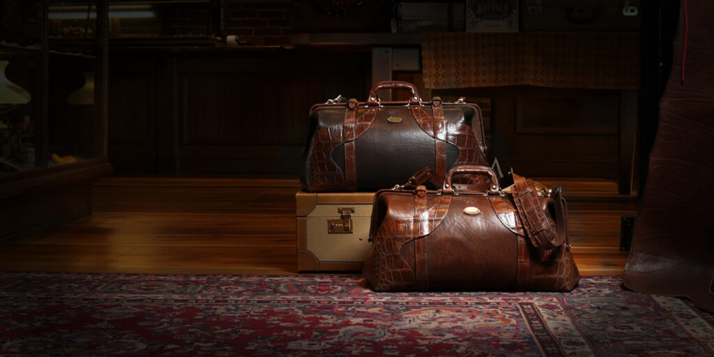 Limited Edition: No. 5 Grip 3 two no 5 grips with alligator trim - steerhide - tobacco buffalo - on a trunk