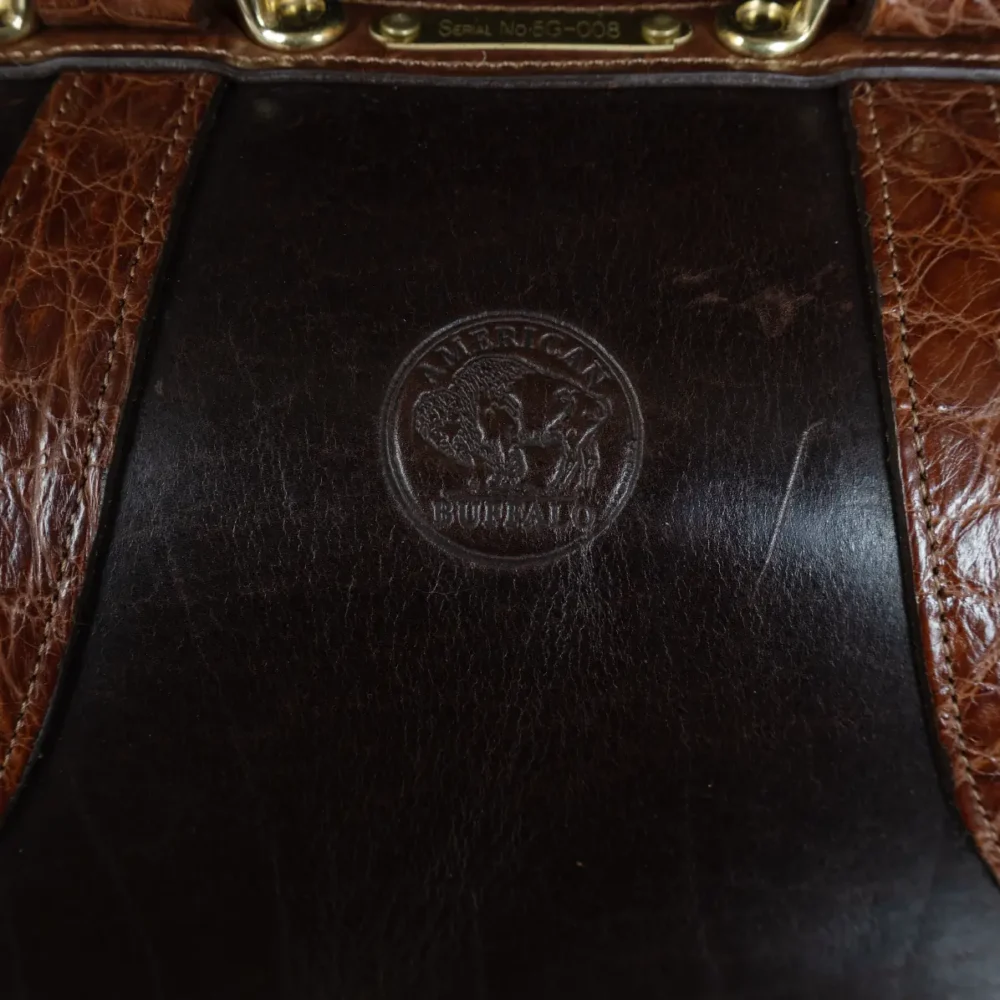 no 5 grip in tobacco buffalo with brown american alligator trim - view of stamp - on a wood table with black background - ID 008